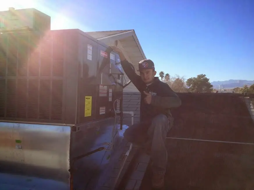 HVAC technician performing Heat Pump Repair on a rooftop unit in Tell City